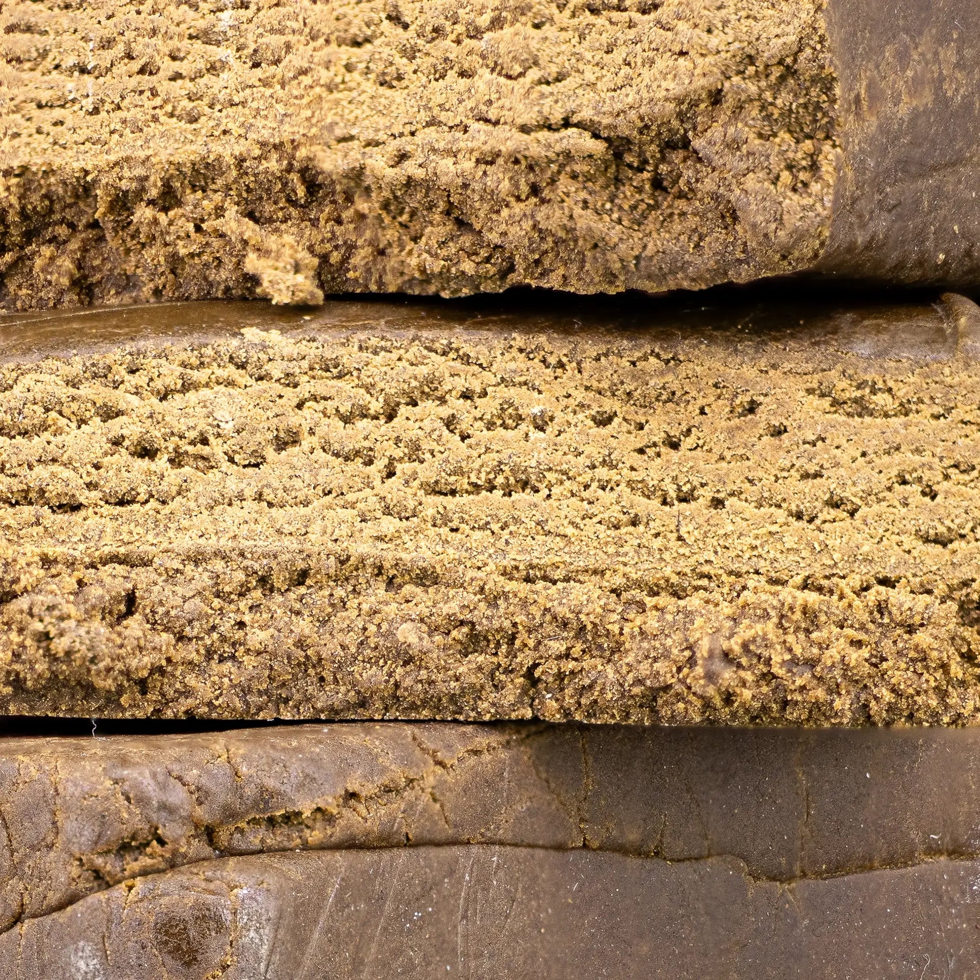 Close-up of Luxus Ketama hash showing golden brown interior texture